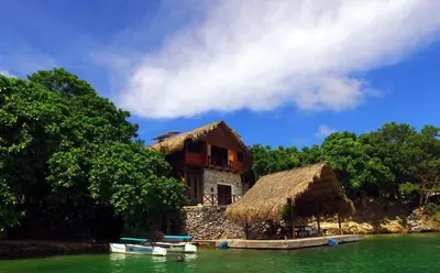a house on the shore of a body of water at Isla Única- Islas del Rosario in Isla Grande