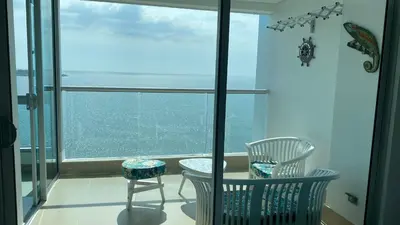 a balcony with two chairs and a table in front of a window at Apartamento Frente al Mar in Cartagena de Indias