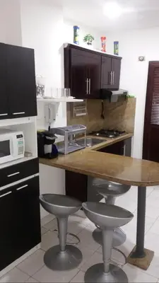 a kitchen with a table and two bar stools at Cartagena Escape Plaza in Cartagena de Indias
