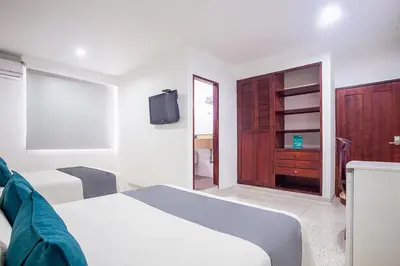 a bedroom with a bed and a tv on the wall at Ayenda Hotel Carivdi in Sincelejo