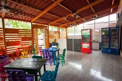 a restaurant with tables and chairs and a soda machine at Hostal El Bando in Cartagena de Indias