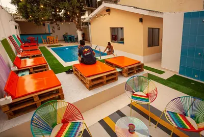 an overhead view of a pool with chairs and a man sitting next to a table at Hostal El Bando in Cartagena de Indias