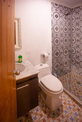 a bathroom with a toilet and a sink and a shower at Hostal El Bando in Cartagena de Indias