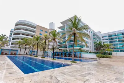 a swimming pool with palm trees in front of buildings at Morros 922 una alcoba Edificio frente al mar in Cartagena de Indias