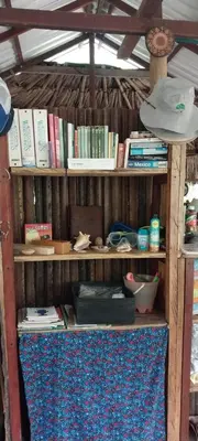 a book shelf filled with books and other items at Eco-Camping Mango Feliz Rincón del Mar in San Onofre