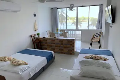 two beds in a room with a balcony at Apartamento cerca de playas y zonas turísticas in Cartagena de Indias