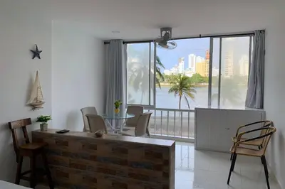 a living room with a table and chairs and a large window at Apartamento cerca de playas y zonas turísticas in Cartagena de Indias