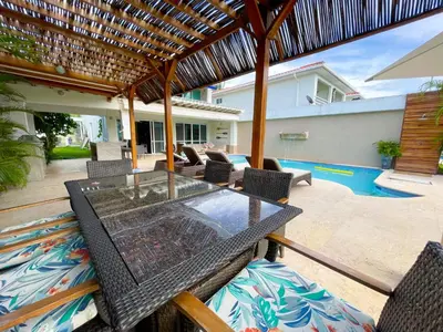 an outdoor patio with a glass table and chairs at Casa de Playa in Cartagena de Indias