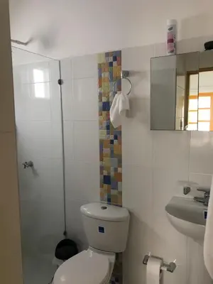 a white bathroom with a toilet and a sink at Bahia Tropical Sandia Kiwi Piña in Coveñas