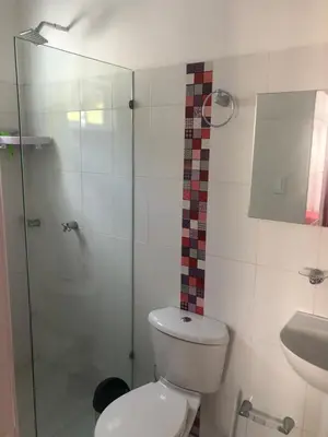 a bathroom with a toilet and a glass shower at Bahia Tropical Sandia Kiwi Piña in Coveñas