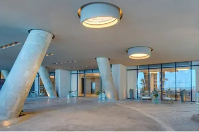 a large lobby with columns and tables and windows at 31st Perfect Seaview Bocagrande Morros City in Cartagena de Indias