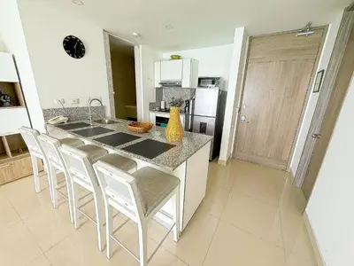a kitchen with a counter and a kitchen island with chairs at 31st Perfect Seaview Bocagrande Morros City in Cartagena de Indias