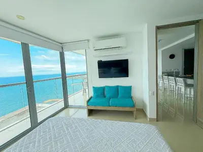 a bedroom with a blue couch and a view of the ocean at 31st Perfect Seaview Bocagrande Morros City in Cartagena de Indias