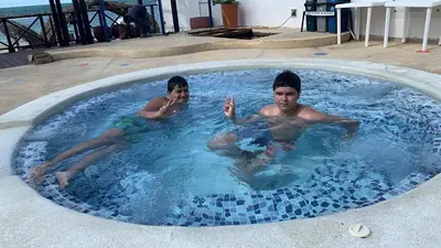 two young men are swimming in a swimming pool at Hotel Portobello in Coveñas