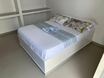 a white bed with two pillows on top of it at Hotel Portobello in Coveñas