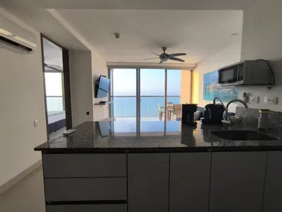 a kitchen with a counter with a view of the ocean at Apartamentos frente al mar en Morros City in Cartagena de Indias