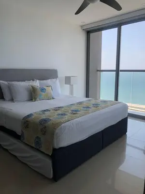 a bedroom with a large bed with a large window at Apartamentos frente al mar en Morros City in Cartagena de Indias