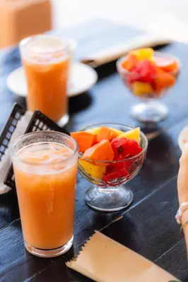 a table with a bowl of fruit and glasses of juice at Hotel Marie Real Cartagena in Cartagena de Indias