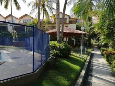a tennis court in front of a house with palm trees at Casa, playa Bello Horizonte Santa Marta Colombia in Santa Marta