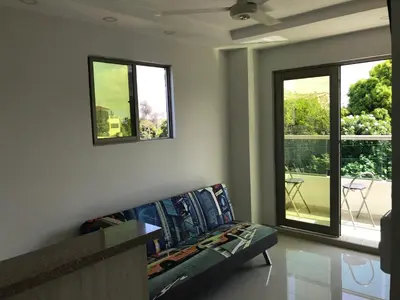 a living room with a couch and two windows at Hostal Cartagena Sun in Cartagena de Indias