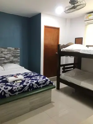 a bedroom with a bed and two bunk beds at Hostal Cartagena Sun in Cartagena de Indias