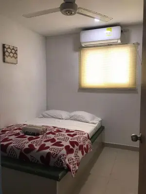 a bedroom with a bed with a red and white blanket at Hostal Cartagena Sun in Cartagena de Indias