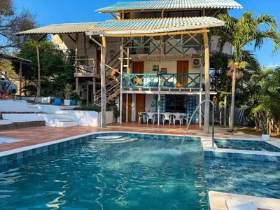a house with a swimming pool in front of a house at PALOMAR EcoCabaña in Santa Veronica