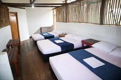 a group of four beds in a room at PALOMAR EcoCabaña in Santa Veronica
