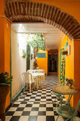 a patio with a table and chairs on a checkered floor at Casa Renacer in Cartagena de Indias