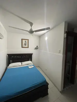 a bedroom with a blue bed and a ceiling fan at Hotel Mangata in Cartagena de Indias