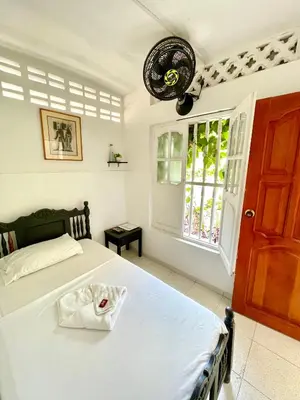 a bedroom with a bed and a window at Hotel Mangata in Cartagena de Indias
