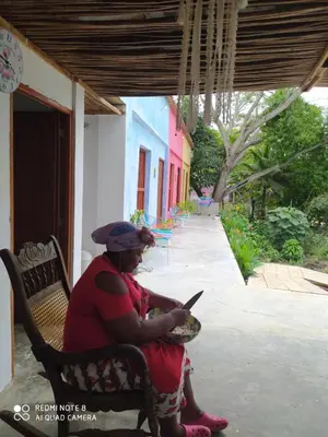 a woman sitting on a bench looking at a cell phone at Los Versos de Zaira in San Onofre