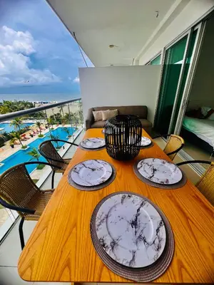 a wooden table with plates on top of a balcony at MORROS EPIC luxury beach in Cartagena de Indias