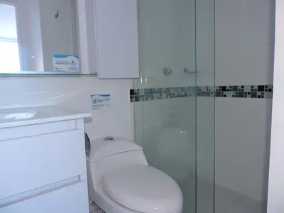 a bathroom with a toilet and a glass shower at Apartamento Mares de Cartagena in Cartagena de Indias