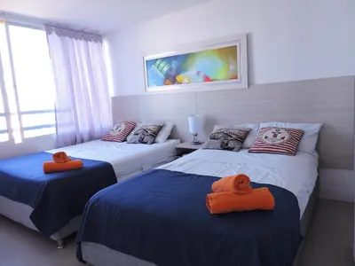 a bedroom with two beds with orange towels on them at Apartamento Mares de Cartagena in Cartagena de Indias