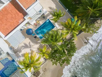 an overhead view of a beach with palm trees and a swimming pool at Quinta Del Mar El francés in Tolú