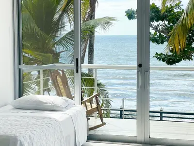 a bedroom with a view of the ocean from a window at Quinta Del Mar El francés in Tolú