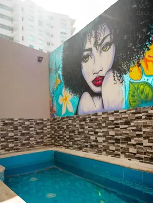 a painting of a woman on a wall next to a swimming pool at Hermosa Habitación cerca al Centro histórico in Cartagena de Indias