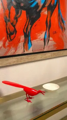 a red dinosaur on a shelf in front of a painting at Lunalá Hotel Boutique in Cartagena de Indias