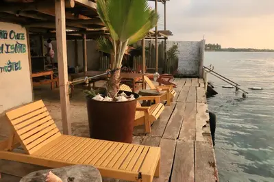 a row of chairs sitting on a dock next to the water at Hostel Santa Cruz del Islote in Santa Cruz del Islote