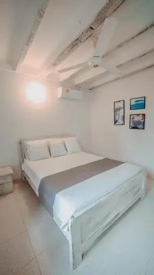 a white bed in a white room with a ceiling at Marbelo Coveñas by Bernalo Hotels in Coveñas