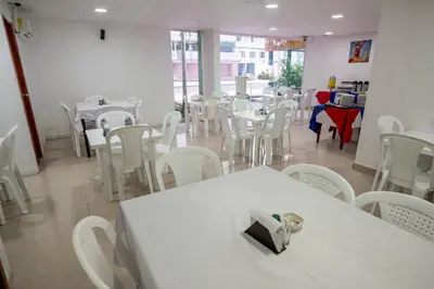 a dining room with white tables and white chairs at Hotel ITACO in Cartagena de Indias
