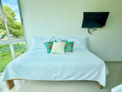 a bedroom with a bed with pillows and a window at Magico Apartamento Frente al Mar 3 Habitaciones B21 in Coveñas
