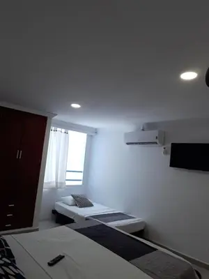 a small bedroom with two beds and a window at Shark 1514 Nuevo Conquistador in Cartagena de Indias