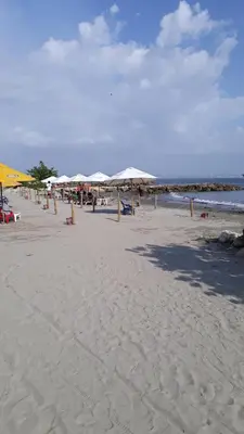 a beach with umbrellas and people on the sand at Shark 1514 Nuevo Conquistador in Cartagena de Indias