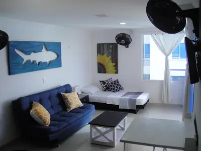 a living room with a blue couch and a bed at Shark 1514 Nuevo Conquistador in Cartagena de Indias