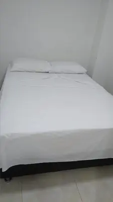 a large white bed sitting in a room at HOTEL BOSQUE DE LAS AMERICAS in Cartagena de Indias