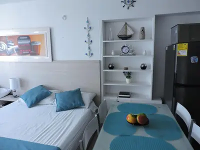 a small room with two beds and a refrigerator at Estudio Loft Cartagena in Cartagena de Indias