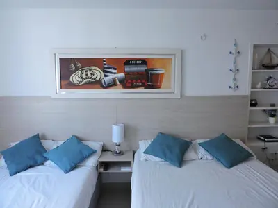 two beds in a room with a picture on the wall at Estudio Loft Cartagena in Cartagena de Indias