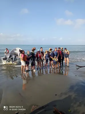 a group of people standing on the beach at HOSTAL BELLEZA TROPICAL in Moñitos